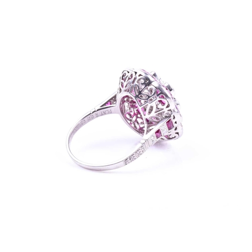 616 - An unusual platinum, diamond, and ruby cocktail ring, centred with a mixed oval-cut ruby, within a b... 