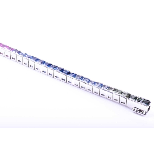 619 - An 18ct white gold and rainbow sapphire bracelet, set with multi-coloured sapphires ranging from gre... 