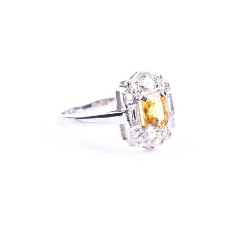 626 - A platinum, diamond, and yellow sapphire ring, in the Art Deco style, set with a mixed-cut sapphire ... 