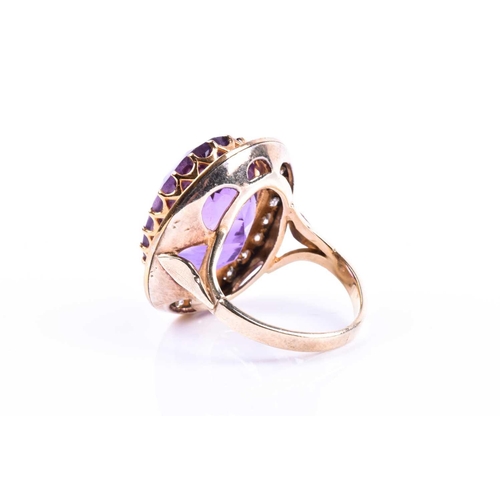 628 - A mid 20th century 18ct yellow gold, diamond, and amethyst cocktail ring, set with a mixed oval-cut ... 