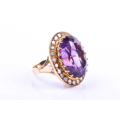 628 - A mid 20th century 18ct yellow gold, diamond, and amethyst cocktail ring, set with a mixed oval-cut ... 