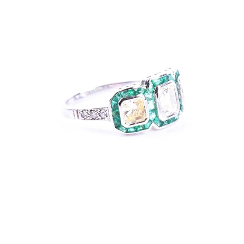 631 - A diamond and emerald ring, set with an emerald-cut diamond flanked with two mixed square-cut diamon... 