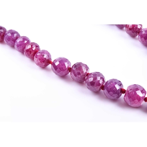 645 - A ruby bead necklace, comprised of graduated faceted corundum beads, approximately 44 cm long, faste... 