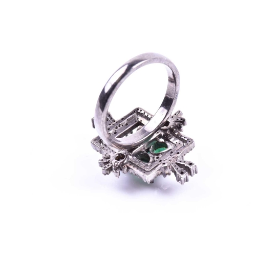 657 - An unusual silver, diamond, and emerald cocktail ring, set with four pear-cut emeralds in a butterfl... 