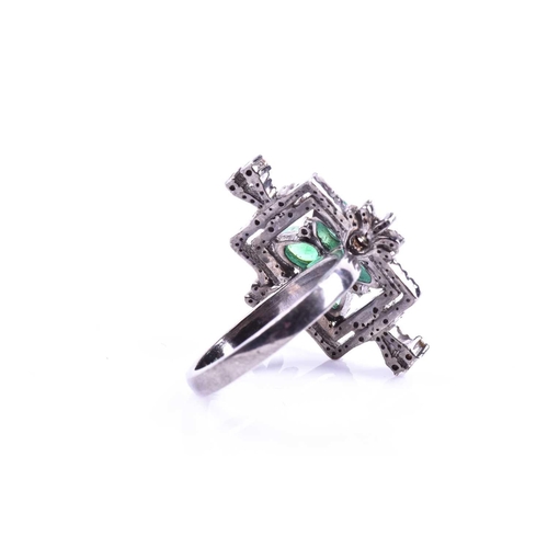 657 - An unusual silver, diamond, and emerald cocktail ring, set with four pear-cut emeralds in a butterfl... 