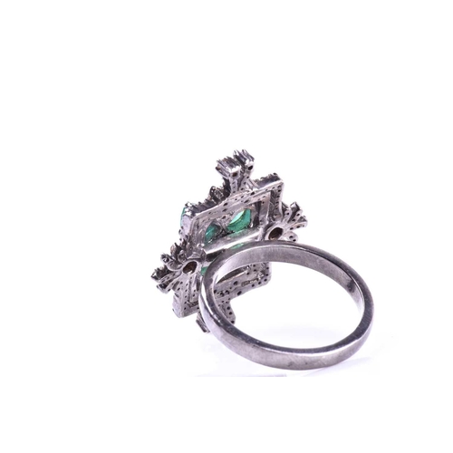 657 - An unusual silver, diamond, and emerald cocktail ring, set with four pear-cut emeralds in a butterfl... 