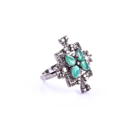 657 - An unusual silver, diamond, and emerald cocktail ring, set with four pear-cut emeralds in a butterfl... 