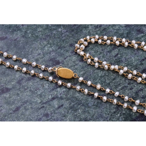 658 - A yellow metal and seed pearl necklace, fastened with a small yellow metal clasp with applied filigr... 