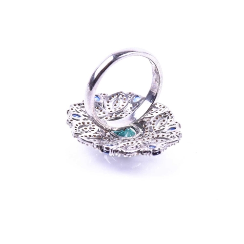 663 - An impressive diamond and emerald cocktail ring, set with a mixed oval-cut emerald within an openwor... 