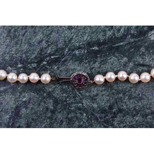 670 - A cultured pearl necklace, individually knotted pearls, approximately 6 mm diameter, fastened with a... 