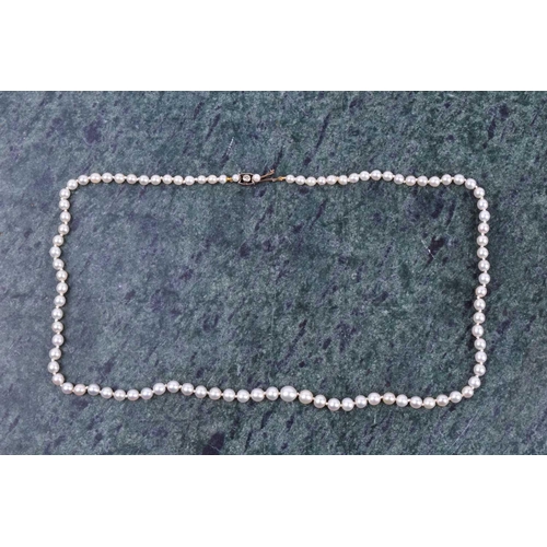 671 - A cultured pearl necklace, set with graduated pearls measuring approximately 3 - 5 mm, fastened with... 