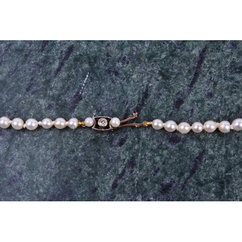 671 - A cultured pearl necklace, set with graduated pearls measuring approximately 3 - 5 mm, fastened with... 