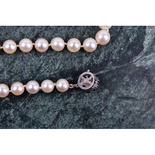 672 - A cultured pearl necklace, set with white pearls of approximately 6-8 mm, fastened with a pearl and ... 