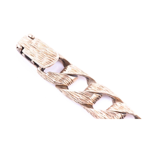 675 - A 9ct yellow gold textured curb-link bracelet, the flattened links with bark-effect design, 19 cm lo... 