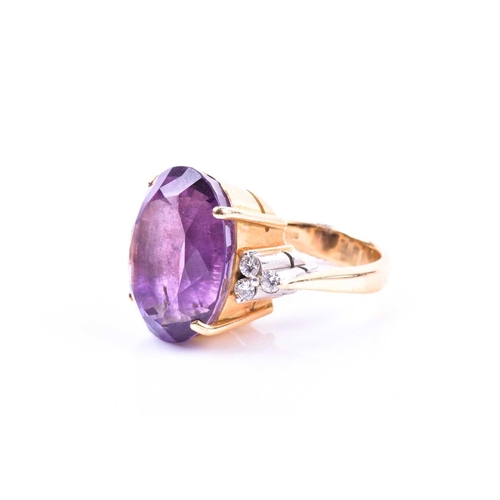 694 - An 18ct yellow gold, diamond, and amethyst cocktail ring, set with a large mixed oval-cut amethyst, ... 