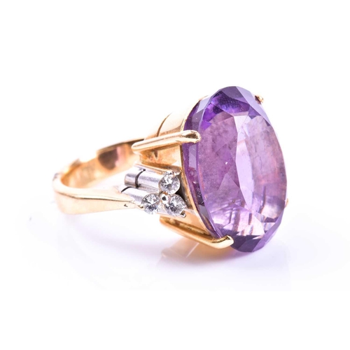 694 - An 18ct yellow gold, diamond, and amethyst cocktail ring, set with a large mixed oval-cut amethyst, ... 