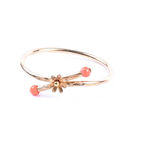 702 - A late 19th / early 20th century yellow metal and coral bracelet, of crossover design, centred with ... 