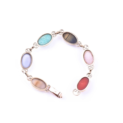 703 - A yellow metal and hardstone bracelet, set with rose quartz, cats eye, and jadeite segments, the cla... 