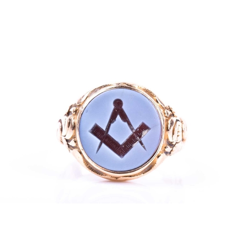 715 - A 15ct yellow gold and onyx Masonic ring, set with a round hardstone plaque depicting the Masonic co... 