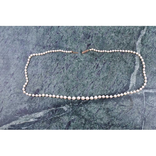 722 - A graduated cultured pearl necklace, the white pearls measuring approximately 3-6 mm, fastened with ... 