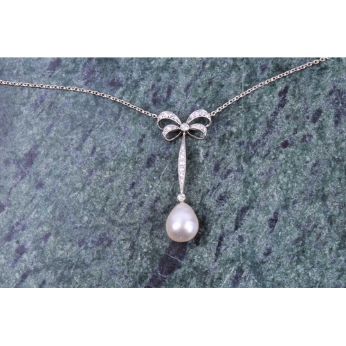 730 - A diamond and pearl drop pendant necklace, the diamond-set bow-shaped mount suspended with a vertica... 