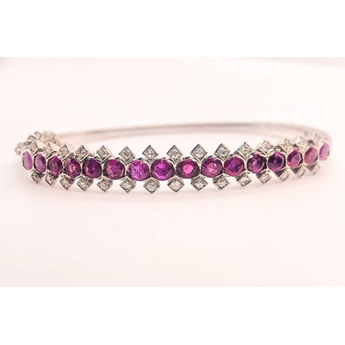 733 - A fine diamond and ruby bangle bracelet, set with a row of mixed-cut rubies of approximately 3.70 ca... 