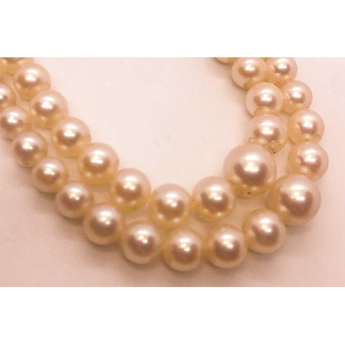 734 - A double strand cultured pearl necklace, the pearls ranging from approximately 3 - 7 mm, fastened wi... 