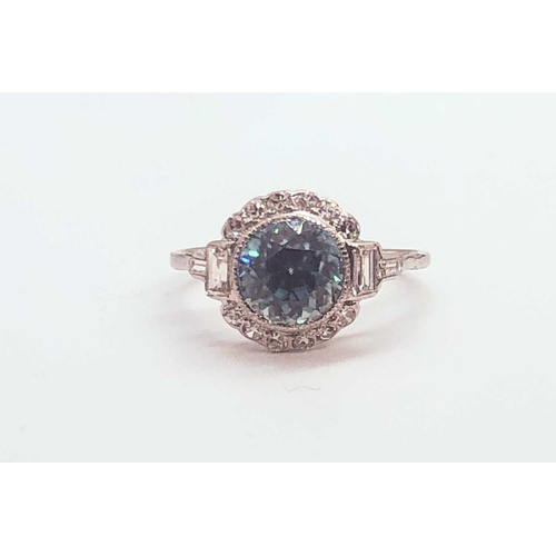 743 - A diamond and blue zircon ring, set with a natural zircon of approximately 2.54 carats, within a bor... 