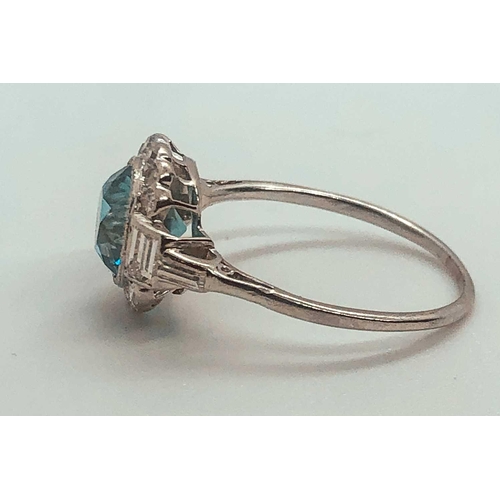 743 - A diamond and blue zircon ring, set with a natural zircon of approximately 2.54 carats, within a bor... 