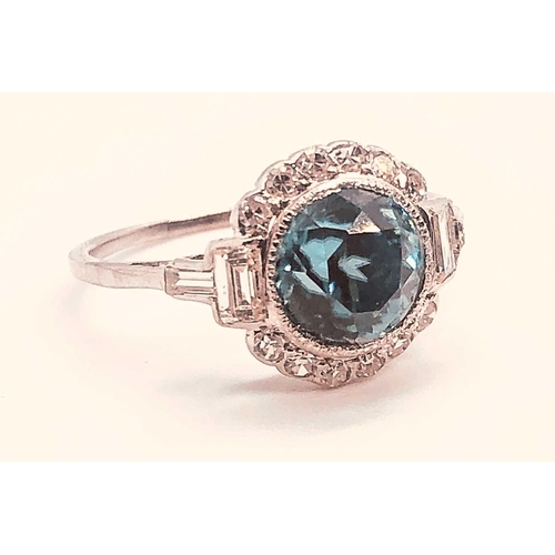 743 - A diamond and blue zircon ring, set with a natural zircon of approximately 2.54 carats, within a bor... 