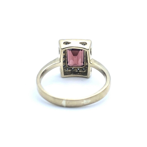 764 - A 9ct yellow gold, diamond, and garnet ring, set with a mixed rectangular-cut garnet, within a recta... 