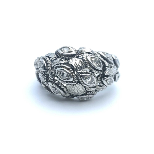 768 - An unusual white metal and cubic zirconia bombe style ring, the stylised navette-shaped mounts inset... 