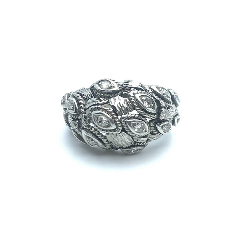 768 - An unusual white metal and cubic zirconia bombe style ring, the stylised navette-shaped mounts inset... 