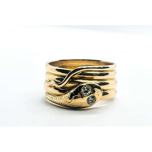 769 - An unusual yellow metal snake ring, the curled snake with two small diamond accent eyes, engraved '2... 