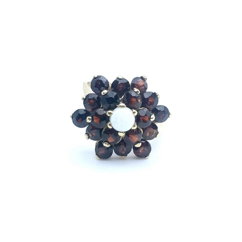 770 - A 9ct yellow gold, garnet, and opal floral cluster ring, size K 1/2, 4.1 grams.