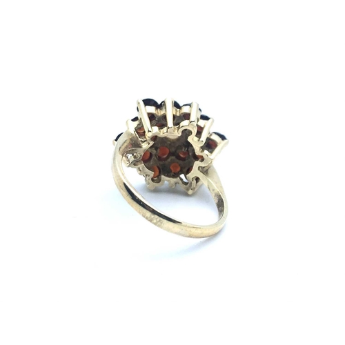 770 - A 9ct yellow gold, garnet, and opal floral cluster ring, size K 1/2, 4.1 grams.