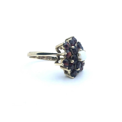 770 - A 9ct yellow gold, garnet, and opal floral cluster ring, size K 1/2, 4.1 grams.