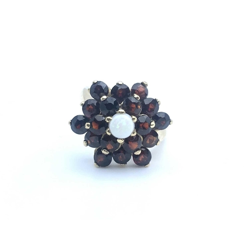 770 - A 9ct yellow gold, garnet, and opal floral cluster ring, size K 1/2, 4.1 grams.