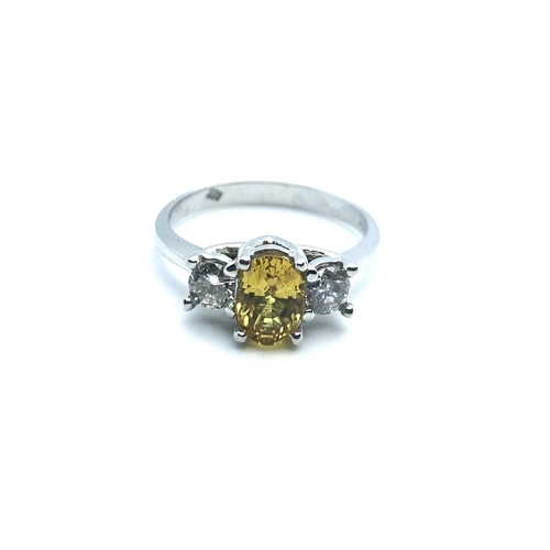 771 - An 18ct white gold, diamond, and yellow sapphire, set with a mixed oval-cut sapphire, flanked with t... 