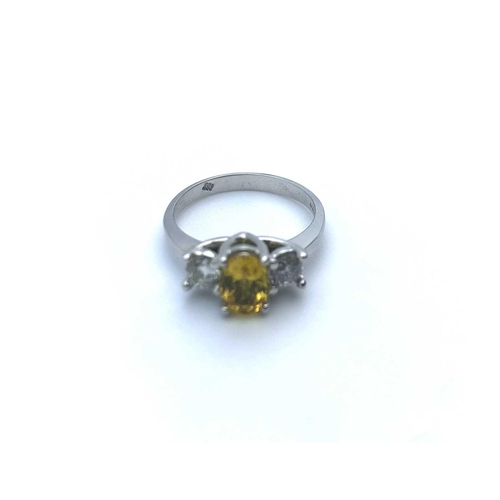 771 - An 18ct white gold, diamond, and yellow sapphire, set with a mixed oval-cut sapphire, flanked with t... 