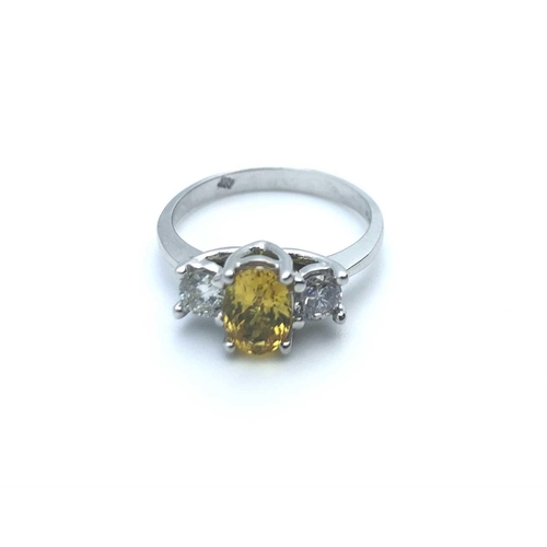 771 - An 18ct white gold, diamond, and yellow sapphire, set with a mixed oval-cut sapphire, flanked with t... 