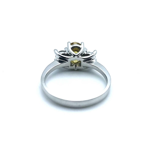 771 - An 18ct white gold, diamond, and yellow sapphire, set with a mixed oval-cut sapphire, flanked with t... 