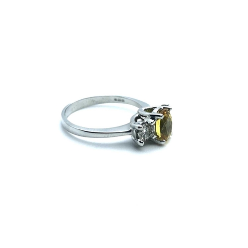 771 - An 18ct white gold, diamond, and yellow sapphire, set with a mixed oval-cut sapphire, flanked with t... 