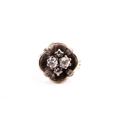 780 - A diamond cluster ring, the white metal mount of quatrefoil design, inset with two old-cut diamonds ... 