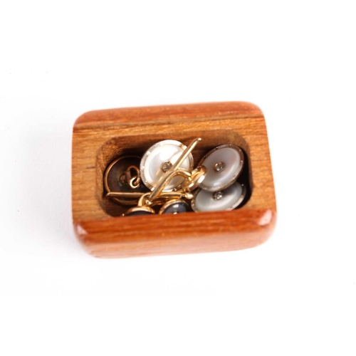 782 - A pair of mother of pearl dress cufflinks and button studs, with diamond set centres, on gold metal ... 