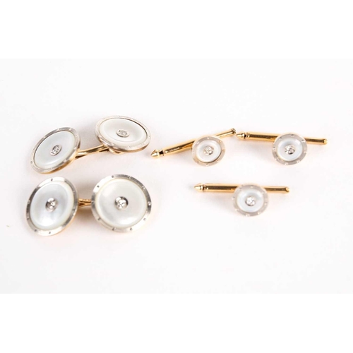 782 - A pair of mother of pearl dress cufflinks and button studs, with diamond set centres, on gold metal ... 