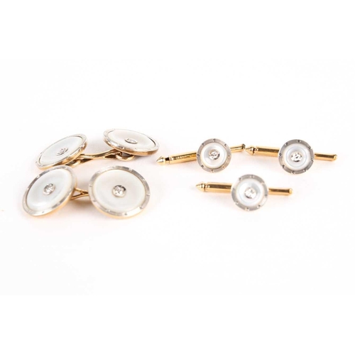 782 - A pair of mother of pearl dress cufflinks and button studs, with diamond set centres, on gold metal ... 