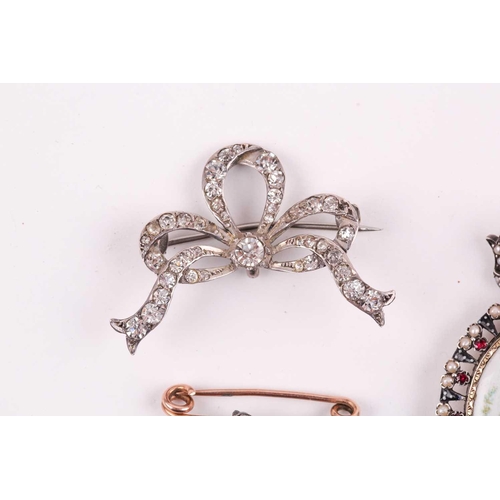 114 - A late 19th century bar brooch, the floral motif set with small rose-cut diamonds, 2.9 cm long, toge... 