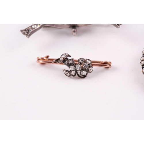 114 - A late 19th century bar brooch, the floral motif set with small rose-cut diamonds, 2.9 cm long, toge... 