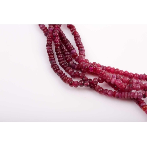 182 - A five strand ruby necklace, comprised of smooth and faceted rubies, with red and gold fabric adjust... 